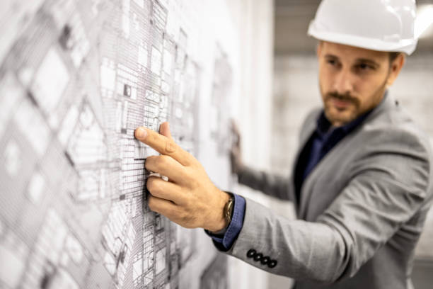 Architect and civil engineer examining structural blueprints on tablet